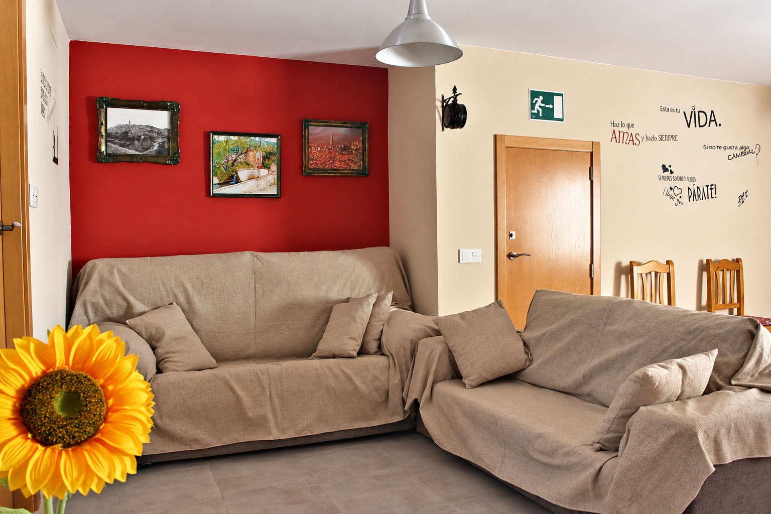 Zona de estar de Casa Rural Bekirent en Bocairent, Valencia, con dos sofás, pared roja y decoración acogedora.