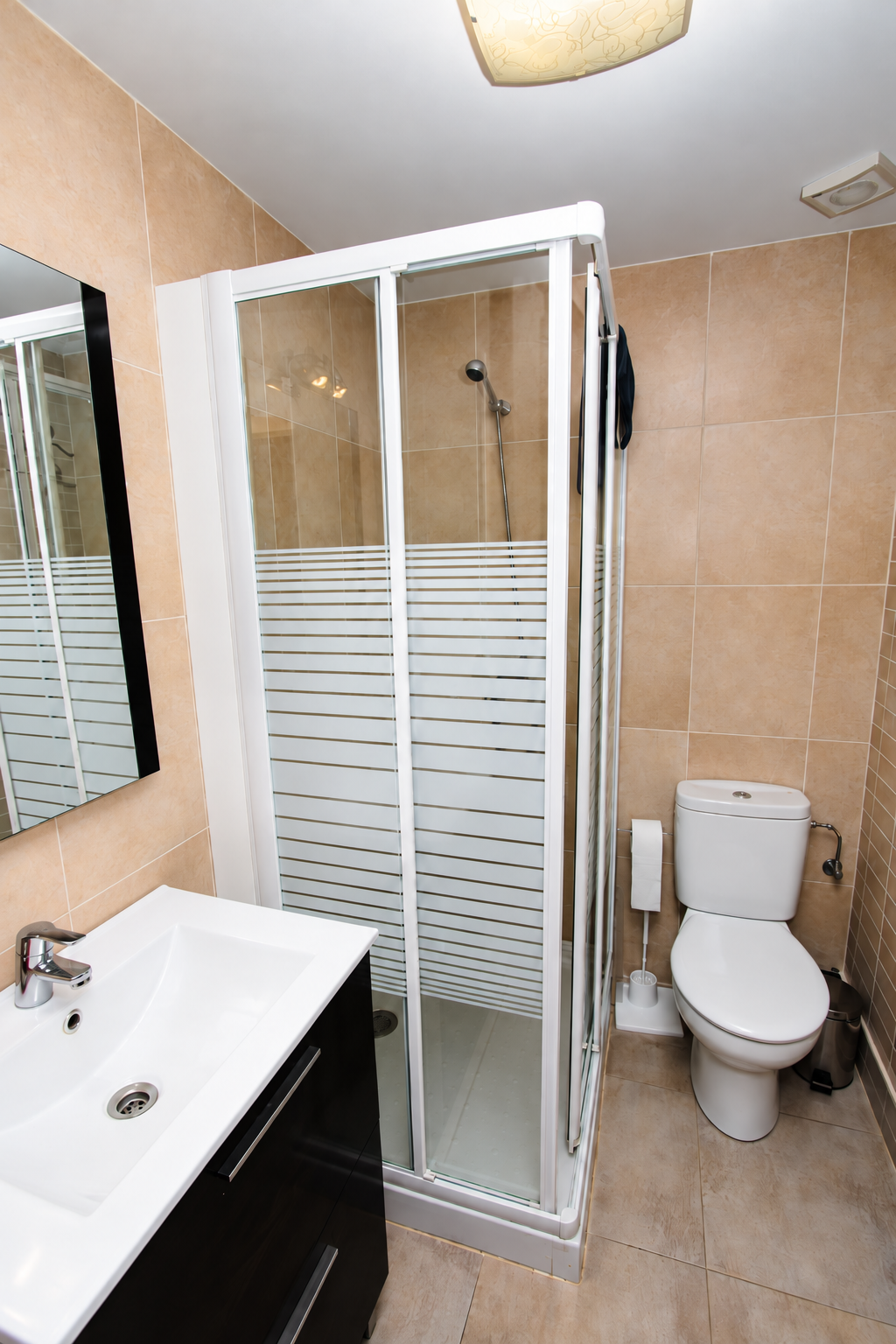 Baño de Casa Rural Bekirent en Bocairent, con ducha de mampara, lavabo con mueble, espejo y WC.